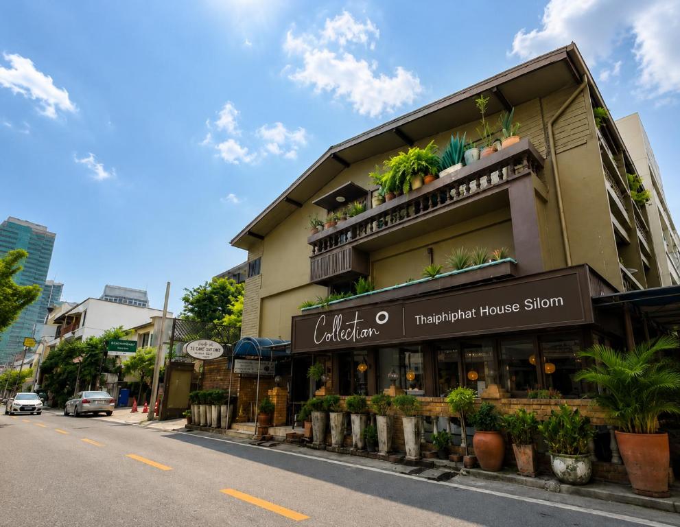 a building with plants on the side of a street at Collection O Thaiphiphat House Silom in Bangkok