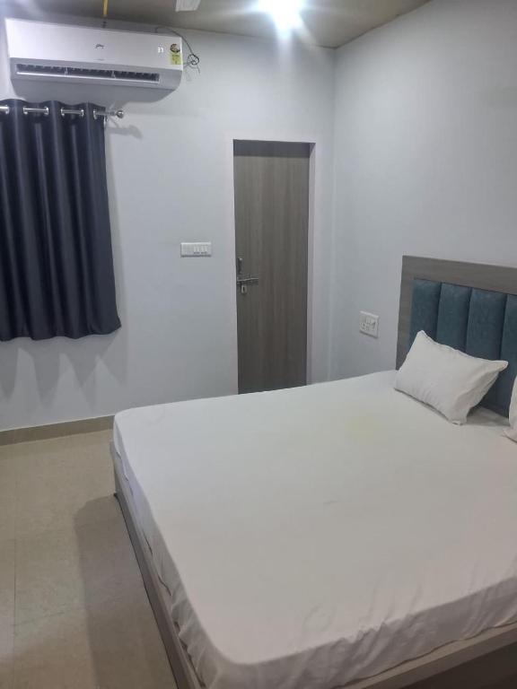 a bedroom with a large white bed and a mirror at HOTEL KRISHNAM Inn in Mathura