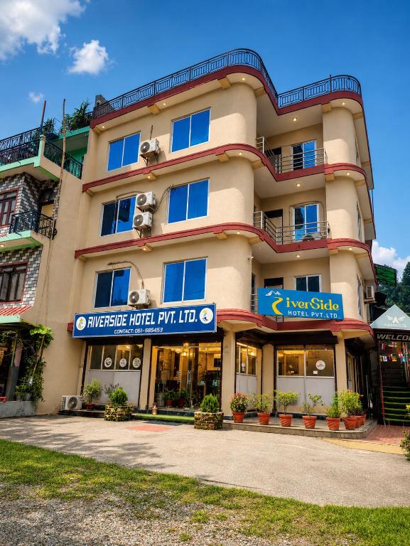 a hotel building with a sign in front of it at River Side Hotel Pvt Ltd in Tanahun