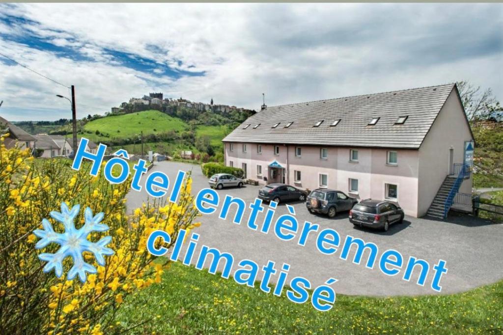 a house with cars parked in front of it at Brit Hotel Essentiel Saint-Flour in Saint-Flour