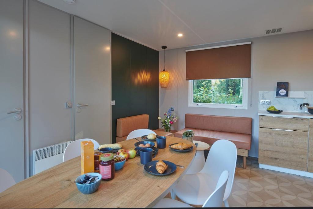 a kitchen and dining room with a table and chairs at Siblu de Tol in Nunspeet