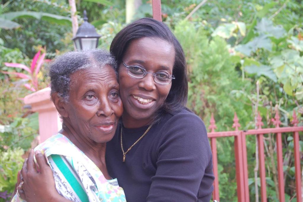 two older women hugging each other in front of a fence at Ruby's Place in Boscobel