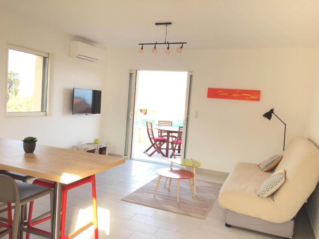 a living room with a table and a dining room at Résidence San Pancraziu in LʼÎle-Rousse
