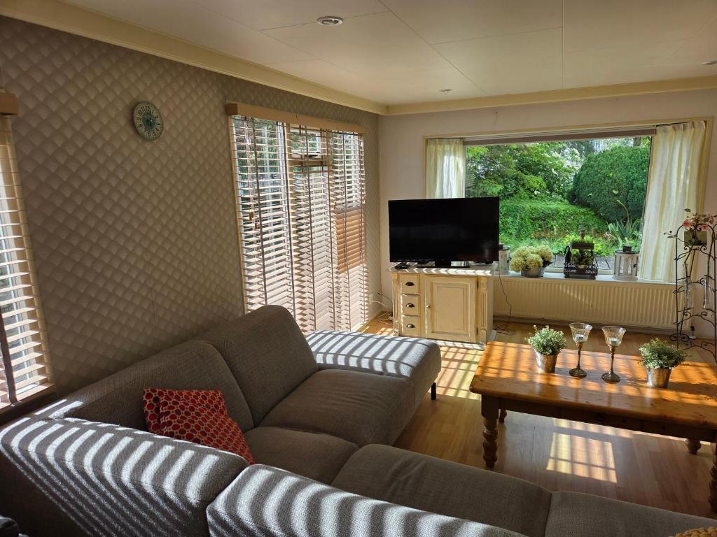 a living room with a couch and a television at Parel in Makkum in Makkum