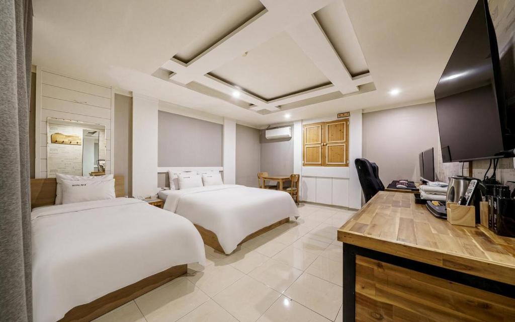 a hotel room with two beds and a television at Cats Hotel in Puch'ŏn-yŏk