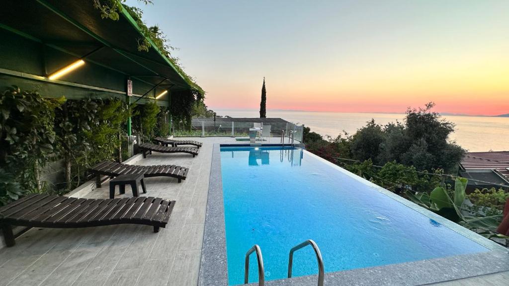 a swimming pool with benches next to a building at Infinity villa in Fethiye