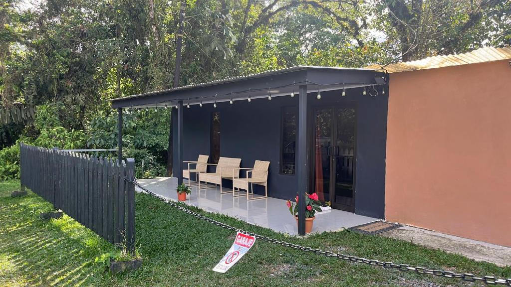 a blue house with chairs and a fence at Pozas y Cascadas La Presa Habitación 3 in Río Cuarto
