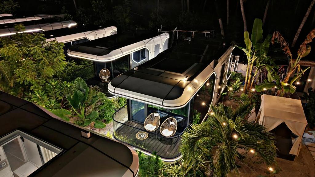 a bus is parked in a garden at night at Sunny Pavilion Thoddoo in Thoddoo