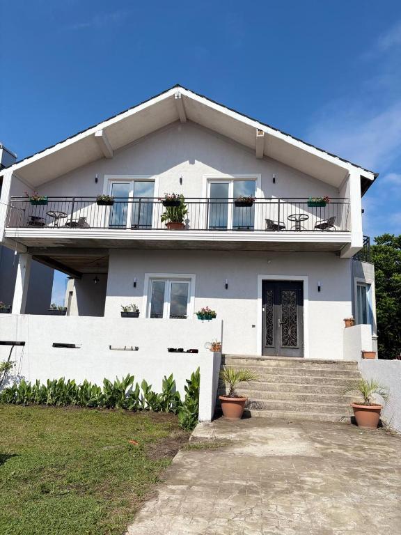 a white house with a balcony and stairs at EmiLiza in Kobuleti