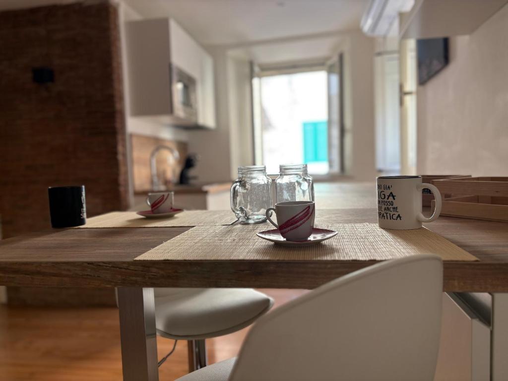 a wooden table with chairs and a table with cups and glasses at Anxur Apartment in Terracina