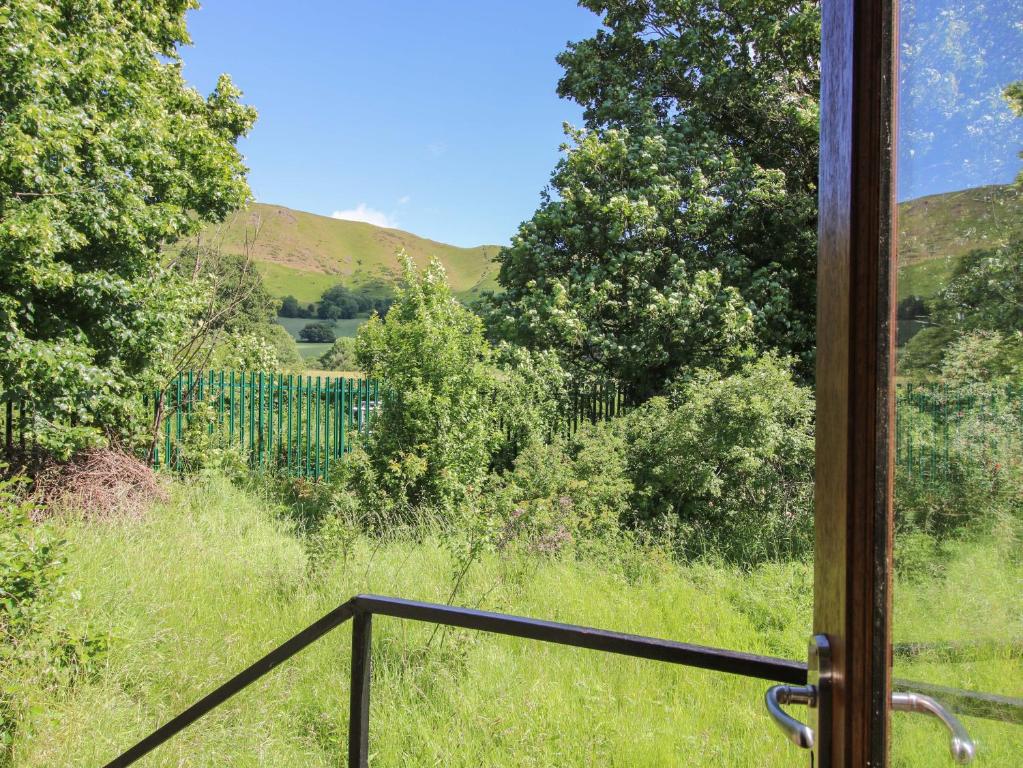 a view from a window of a field with trees at The Millers Roost at Dudgeley Mill in Church Stretton