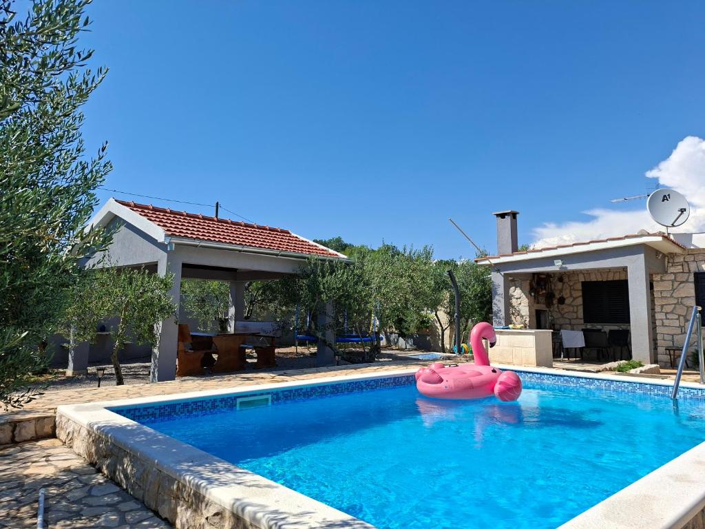 a pink float in a swimming pool next to a house at Villa Frane in Kneževići