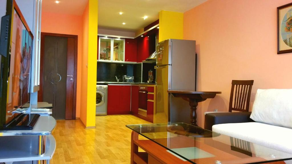 a living room with a white couch and a kitchen at Apartment Asen Apartments - ул Петко Д Петков 64 in Plovdiv