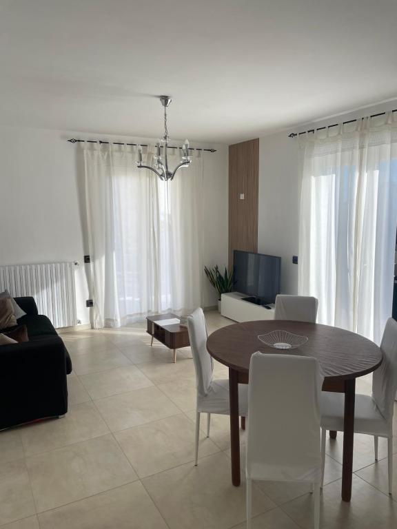 a living room with a table and white chairs at TedHouse in Praia a Mare