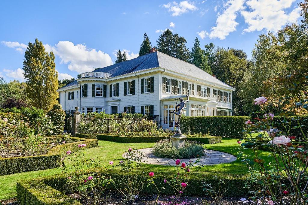 a large white house with a garden in front of it at Fernside Estate and Gardens in Fernside