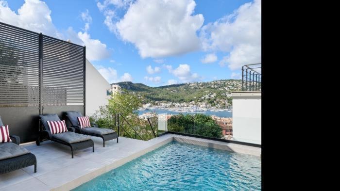 a swimming pool with chairs and a view of the water at The One in Port d'Andratx