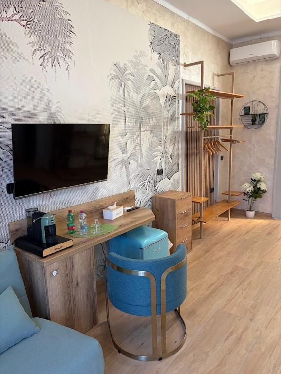 ein Wohnzimmer mit Fernseher und einem blauen Sessel in der Unterkunft Dimora 78 in Capua