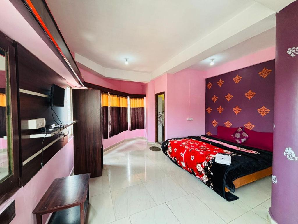 a bedroom with pink and purple walls and a bed at SB Cottage ooty in Ooty