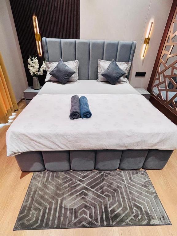 a large bed with a blue headboard on top of it at Galaxy blue sapphire studio in Ghaziabad