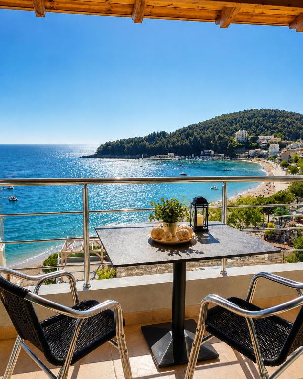 a table and chairs on a balcony with a view of the ocean at Dina's Apartment in Himare