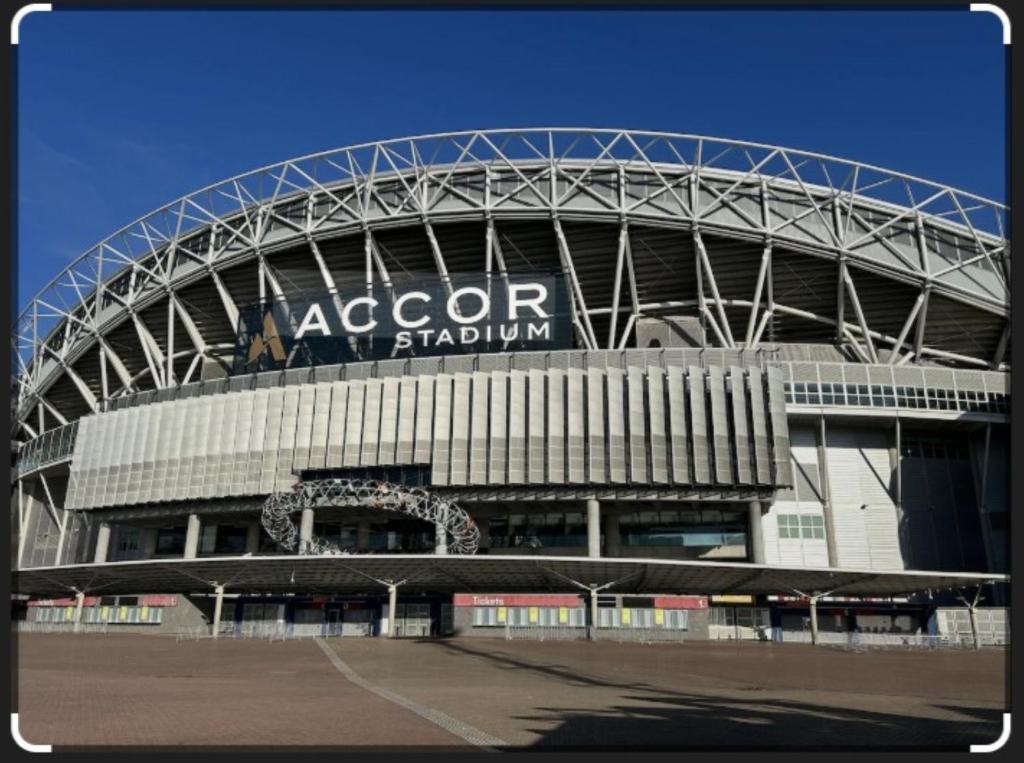 a large stadium with a sign on top of it at Olympicpark 12 Free Parking in Sydney