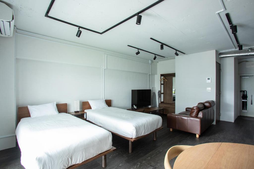a room with two beds and a couch and a table at NIYS apartments 37type in Tokyo