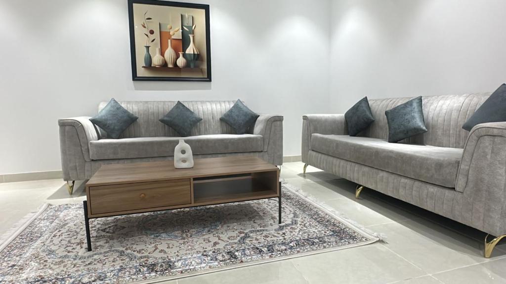 a living room with two couches and a coffee table at أرياف سويت in Al Baha