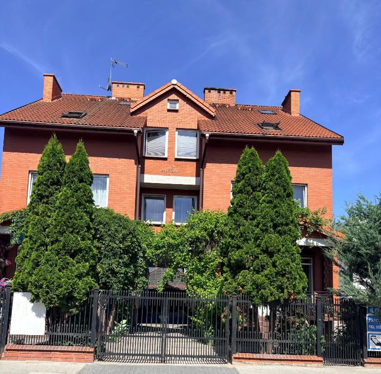 a house with trees in front of a fence at VillaAnita in Augustów