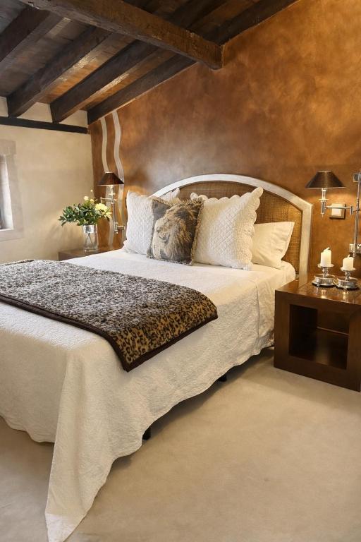 a bedroom with a large white bed with pillows at Hotel Boutique Valle de Oca in Villanasur-Río de Oca