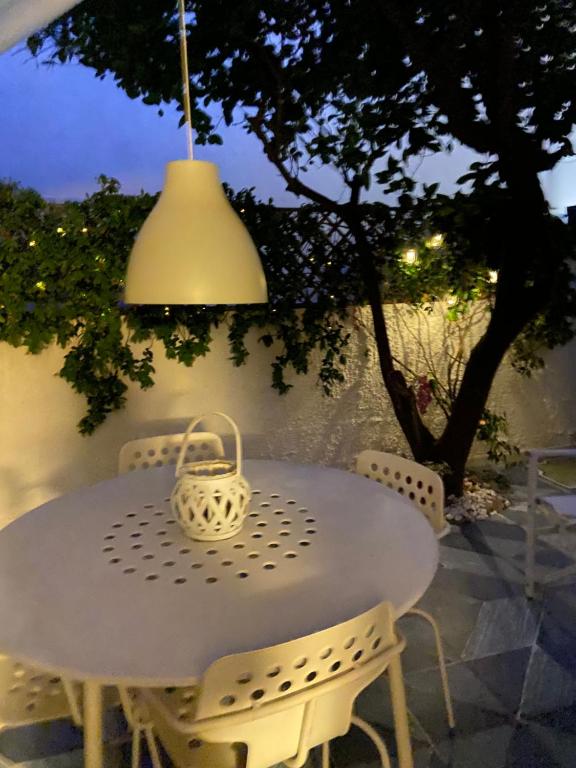 a white table and chairs with a basket on it at Casa Marietta in San Vito lo Capo