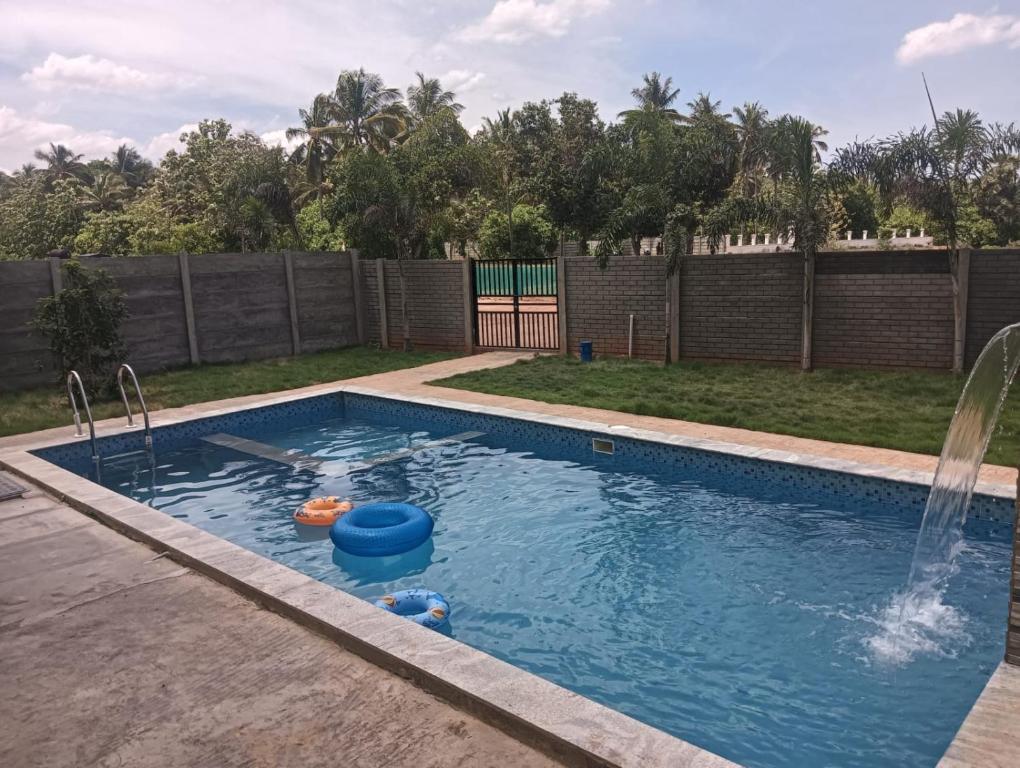 a swimming pool with a fountain in a yard at Auro Green Villa in Pondicherry