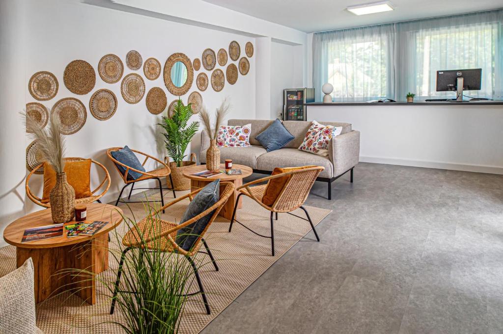 a living room with a couch and tables and chairs at Villa My Garden in Zamárdi