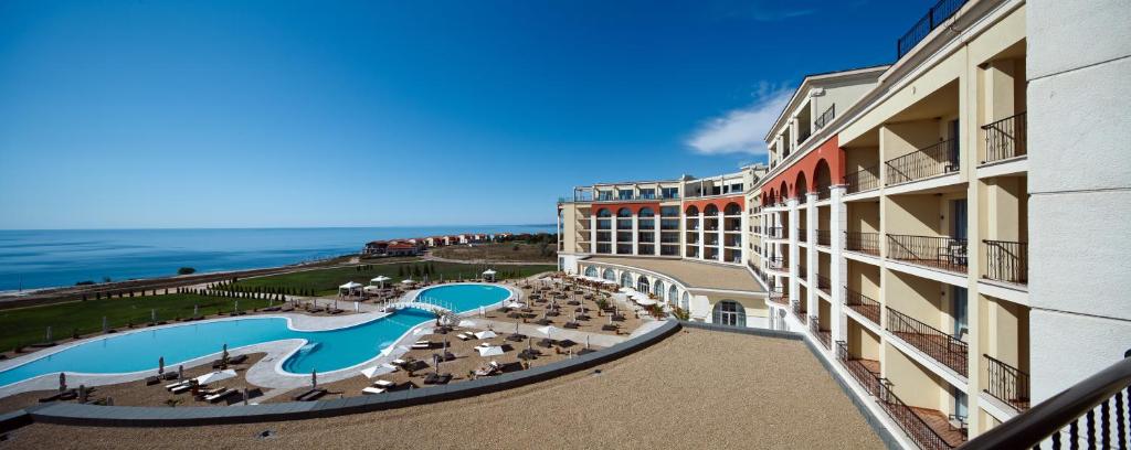 arial view of a hotel with a swimming pool and the ocean at Lighthouse Golf & Spa Hotel - Mineral Pools, Premium All Inclusive, SPA & Beach Access, Free Parking in Balchik