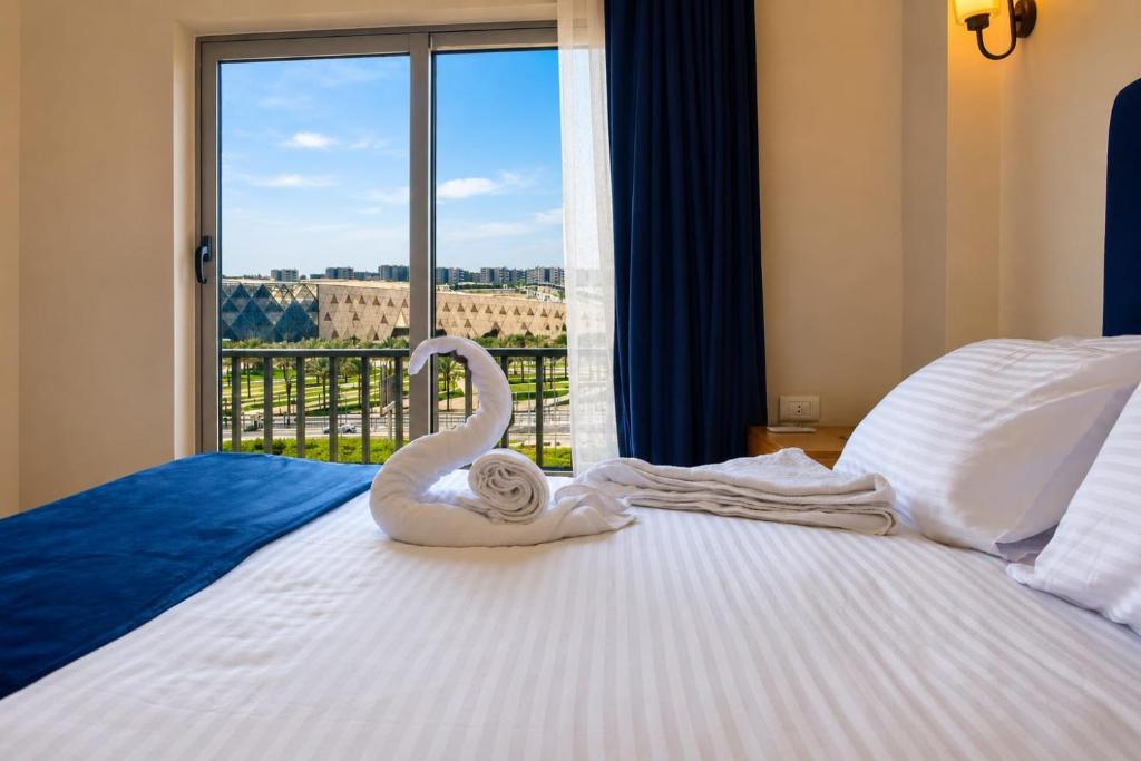 a swan decoration sitting on top of a bed with a window at Kush Hotel, Grand Museum & Pyramids View in Cairo