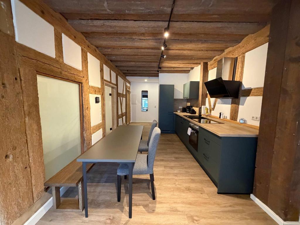 a kitchen with a table and chairs in a room at JURAFLAIR Apartments in Lichtenfels