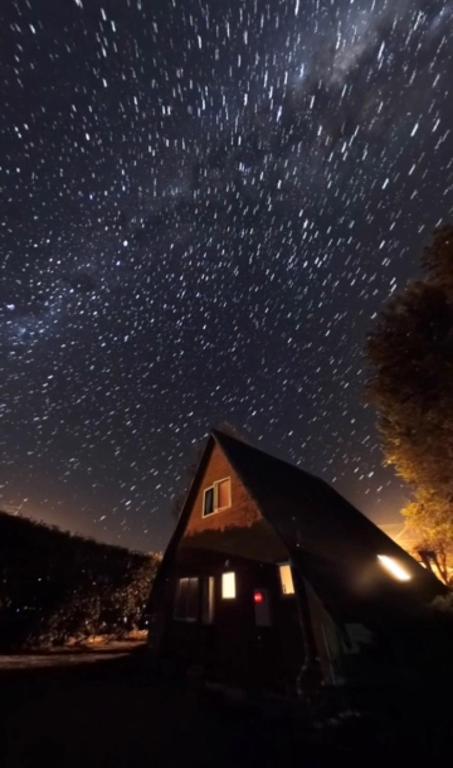 a house under a star filled night sky at Aurora A-Frame Twizel in Twizel