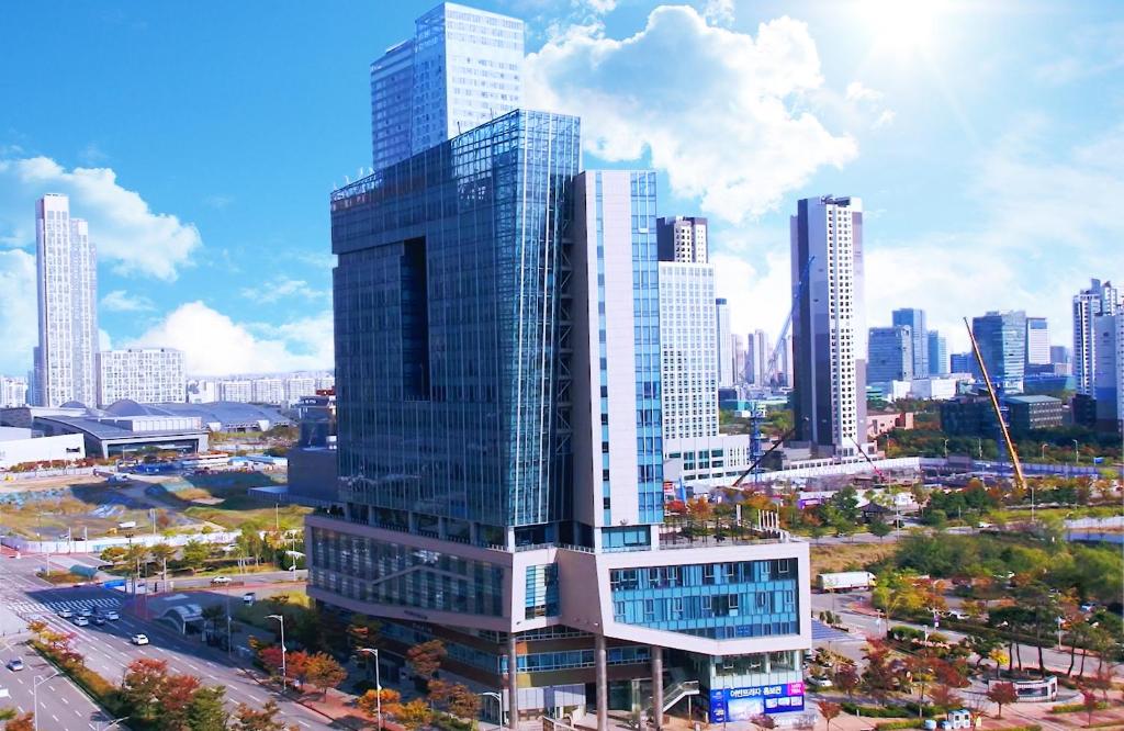a tall building in a city with tall buildings at Bridge Hotel Incheon Songdo in Incheon