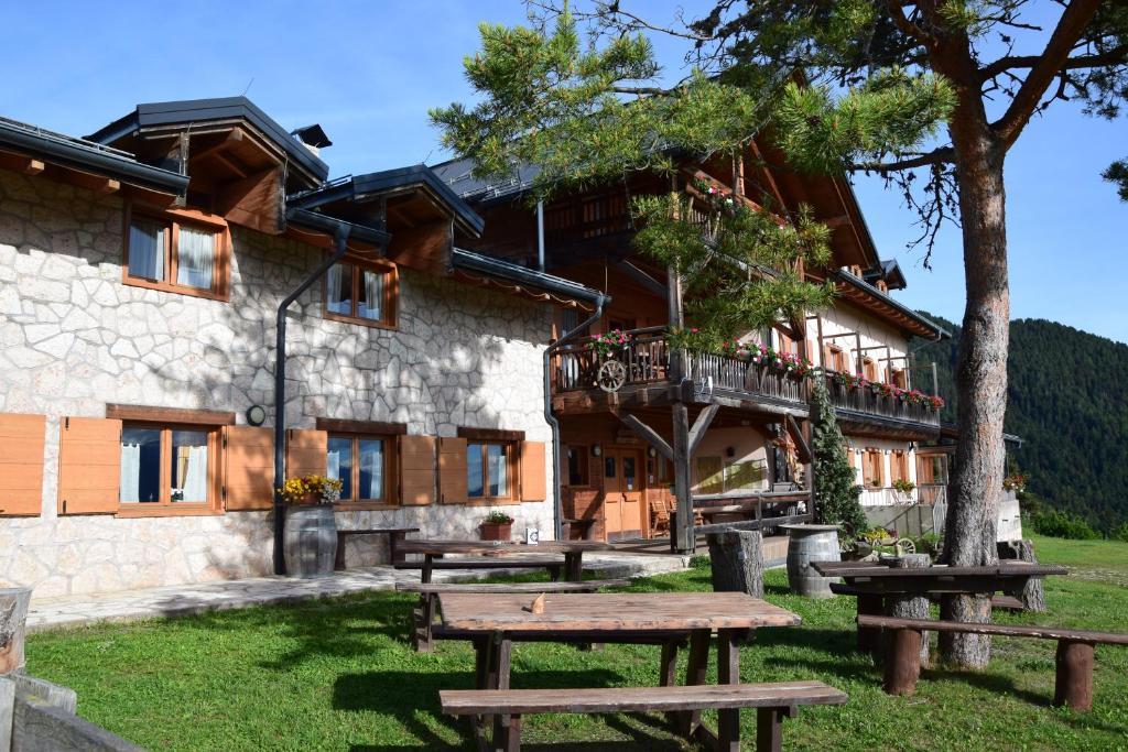 a building with picnic tables in front of it at Rifugio Predaia Ai Todes'ci in Tres
