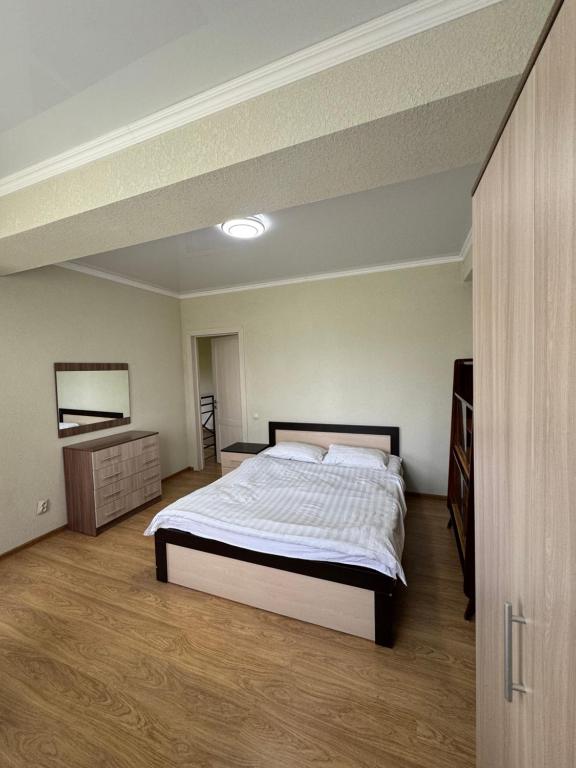 a bedroom with a bed and a dresser in it at HOTEL Vzmorye in Bosteri