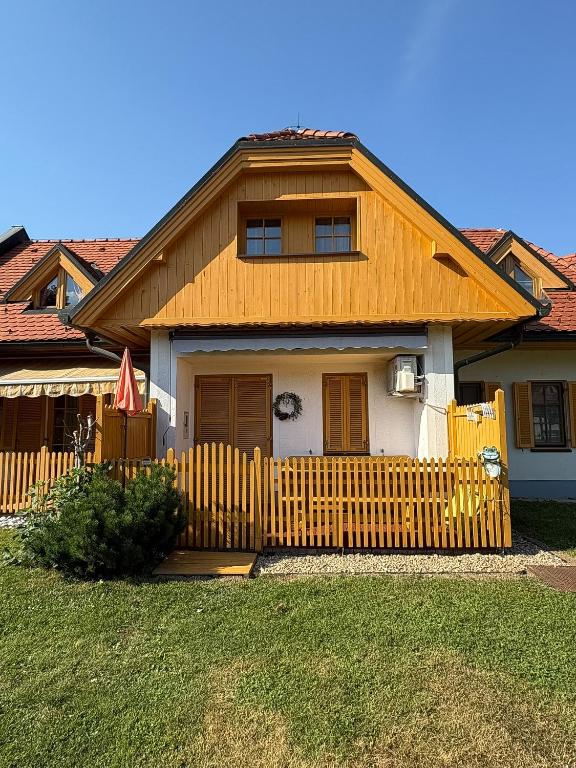 a house with a wooden fence in front of it at Apartma Jelenček in Moravske-Toplice