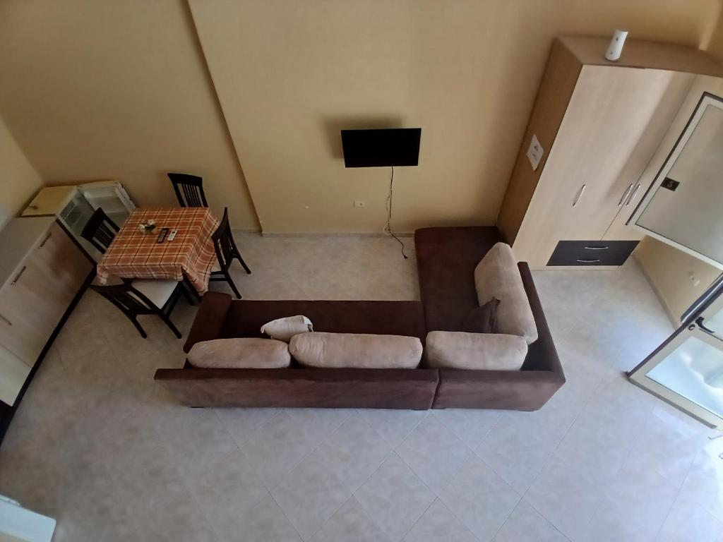 a living room with a brown couch and a table at Proper Apartment in Vlorë