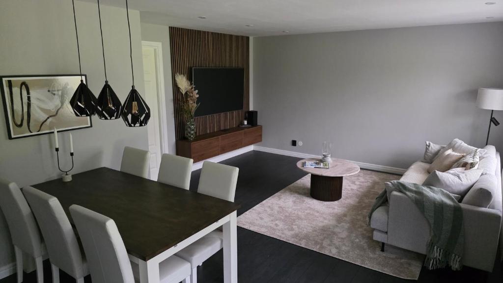 a living room with a dining table and a couch at Modern cosy house with forest views in Södertälje