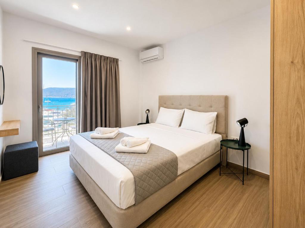 a bedroom with a large bed and a large window at Dolphin hotel in Korfos