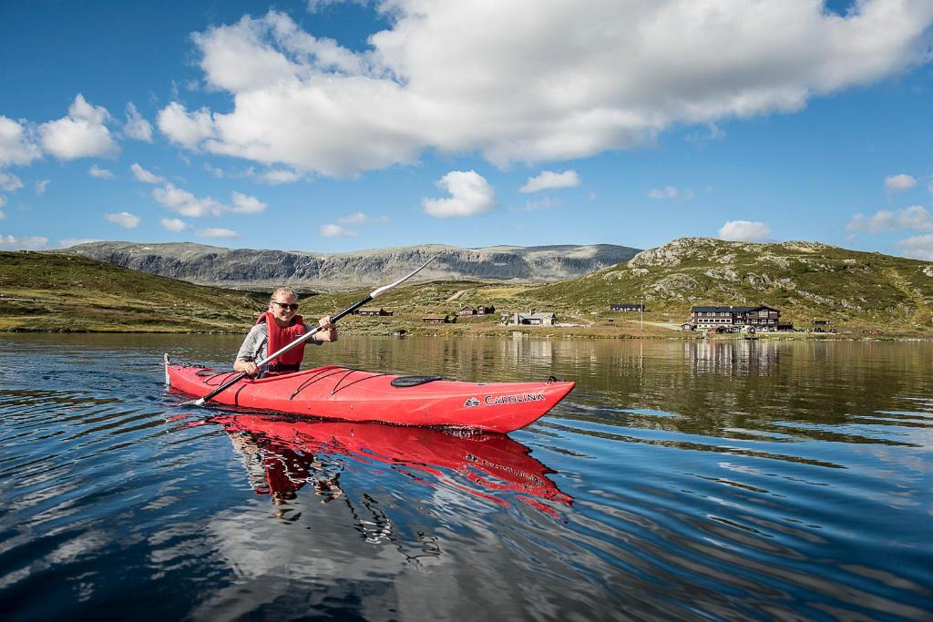 a man in a red kayak on a lake at Bergsjøstølen Fjellstue in Bergsjostolen