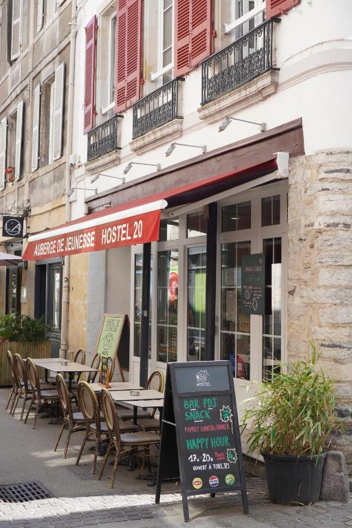 a restaurant with tables and chairs in front of a building at Hostel20 Bayonne in Bayonne