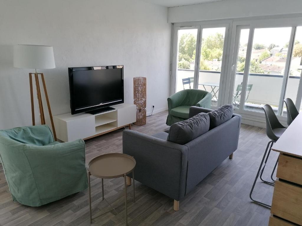 a living room with couches and a flat screen tv at Chambre dans colocation à Lormont proche Bordeaux in Lormont