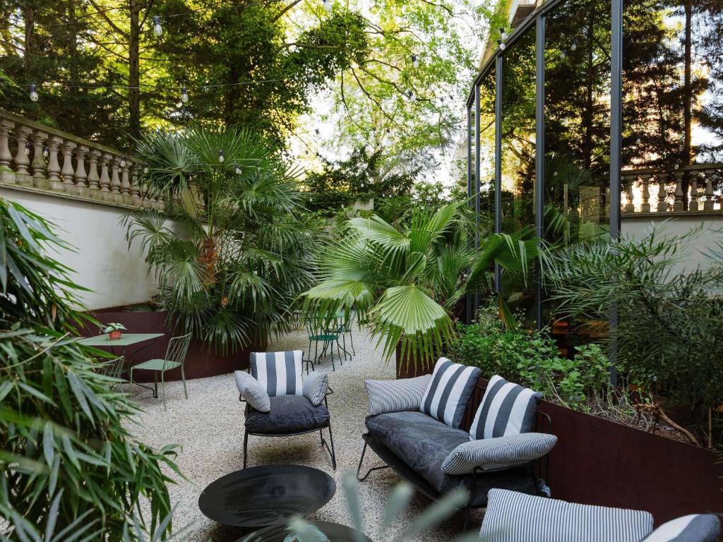 a patio with a couch and chairs and plants at ibis Brussels Centre Chatelain in Brussels