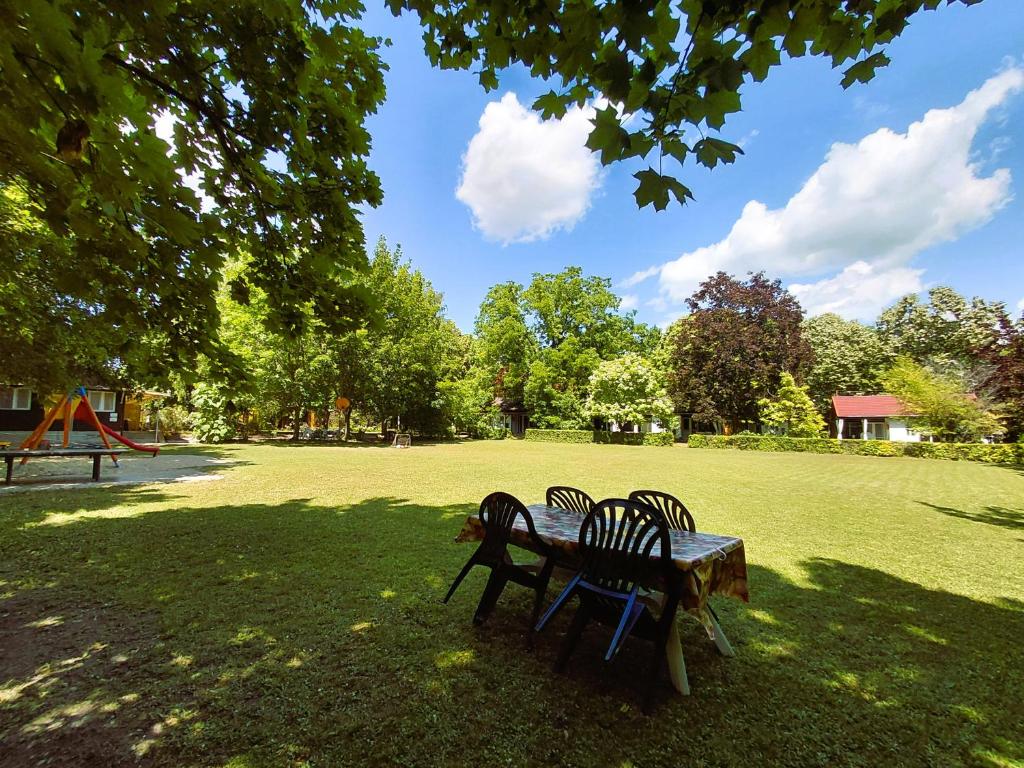 a picnic table and two chairs in a park at Gesztenyés Üdülő in Balatonudvari