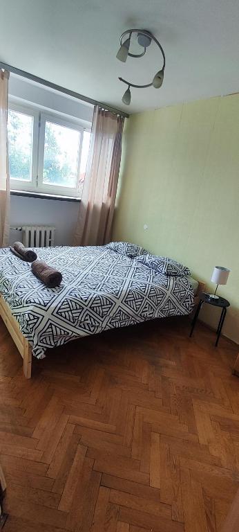 a bedroom with a bed and a wooden floor at Rynek - Nowy Targ in Wrocław
