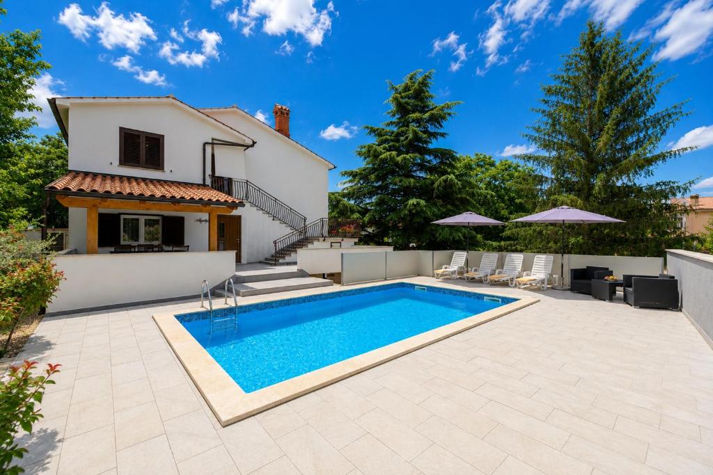 a villa with a swimming pool in front of a house at Magnolia by Briskva in Vinež
